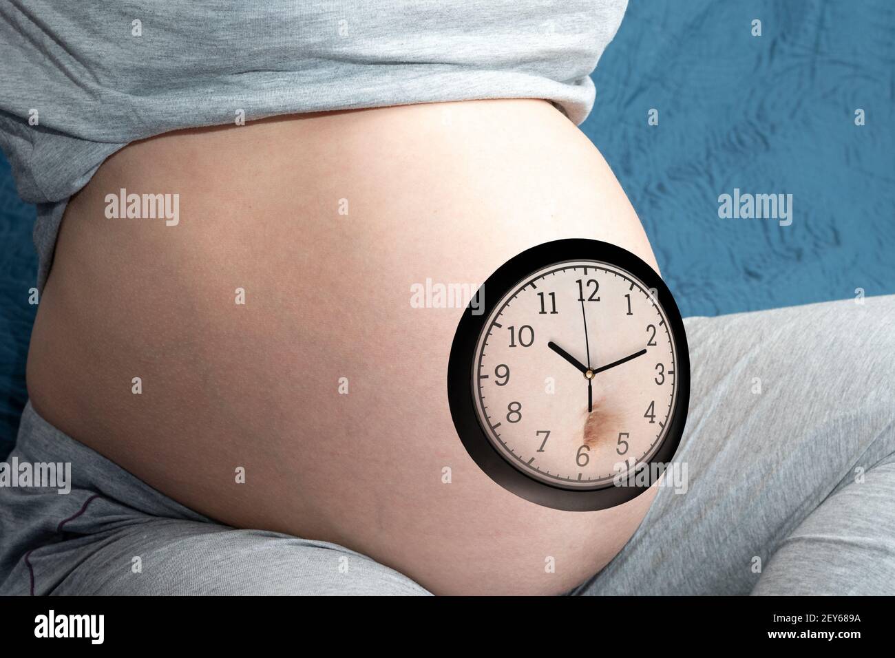 Il concetto di gravidanza. Donna incinta ventre con orologio. Una donna incinta si aspetta un bambino. Concetto di tempo e attesa Foto Stock