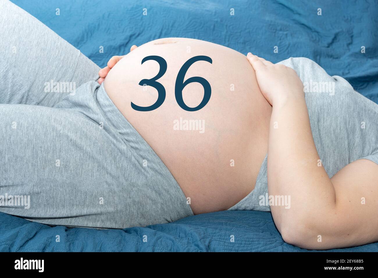 Il concetto di gravidanza. Bella pancia di una donna incinta con un calendario di 36 settimane. Una donna incinta si aspetta un bambino. Concetto di tempo e attesa Foto Stock