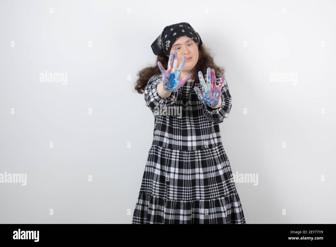 Giovane ragazza con sindrome di Down che mostra i colori su sfondo bianco Foto Stock