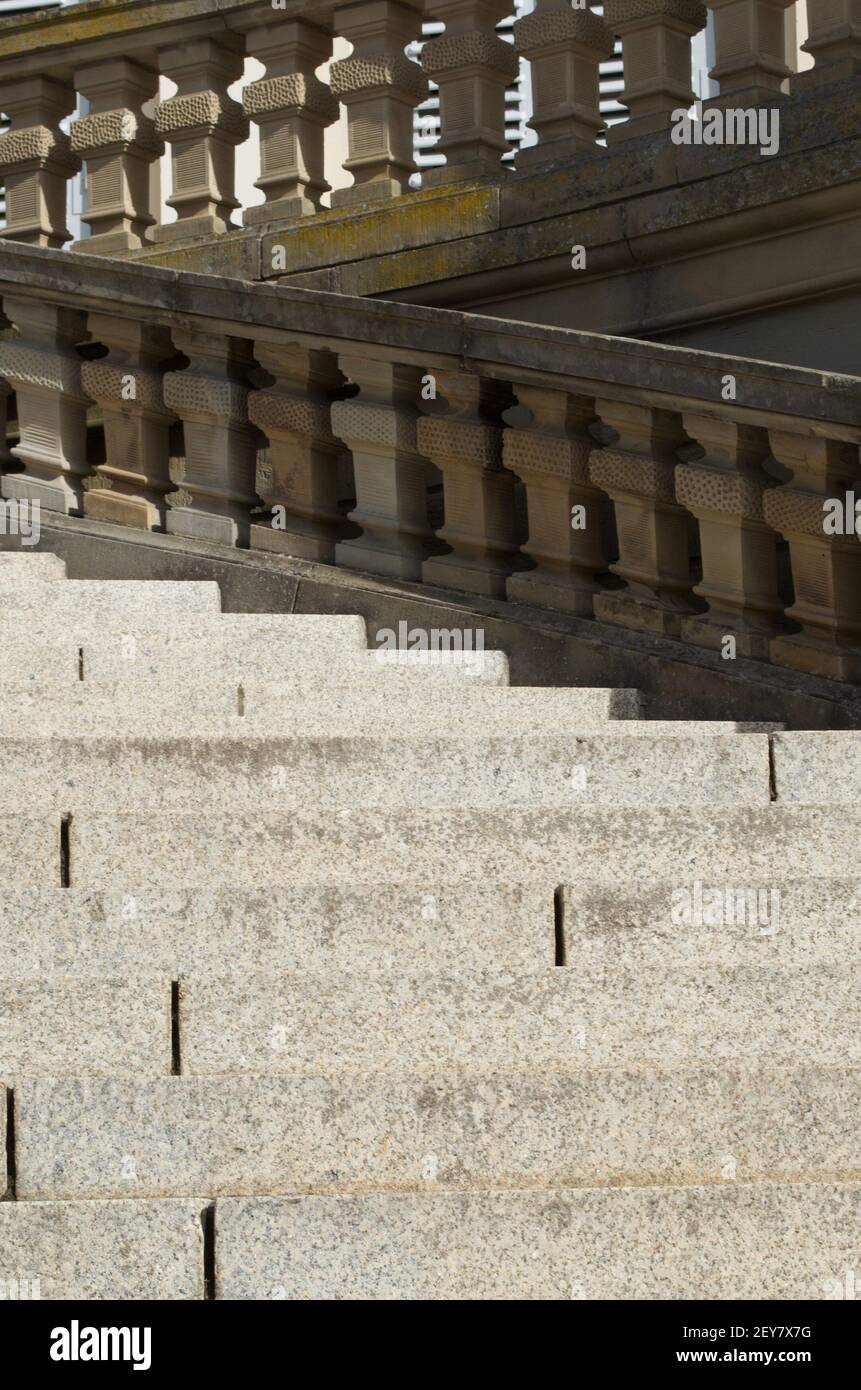 Scalini di pietra circondati da una ringhiera di pietra in ombra parziale Foto Stock