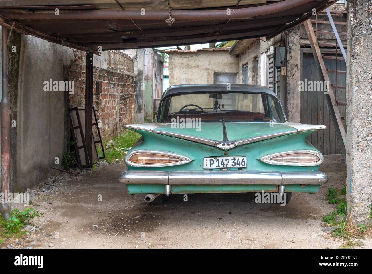 Vecchia auto americana d'epoca in un garage rustico, Santa Clara, Cuba Foto Stock