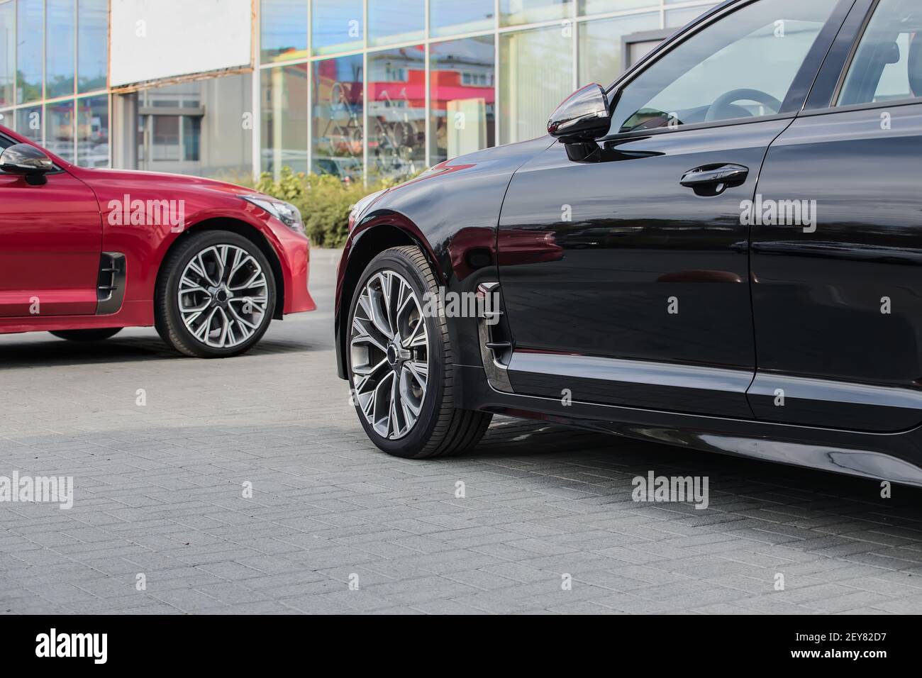 auto rossa e nera vicino all'ufficio vendite Foto Stock