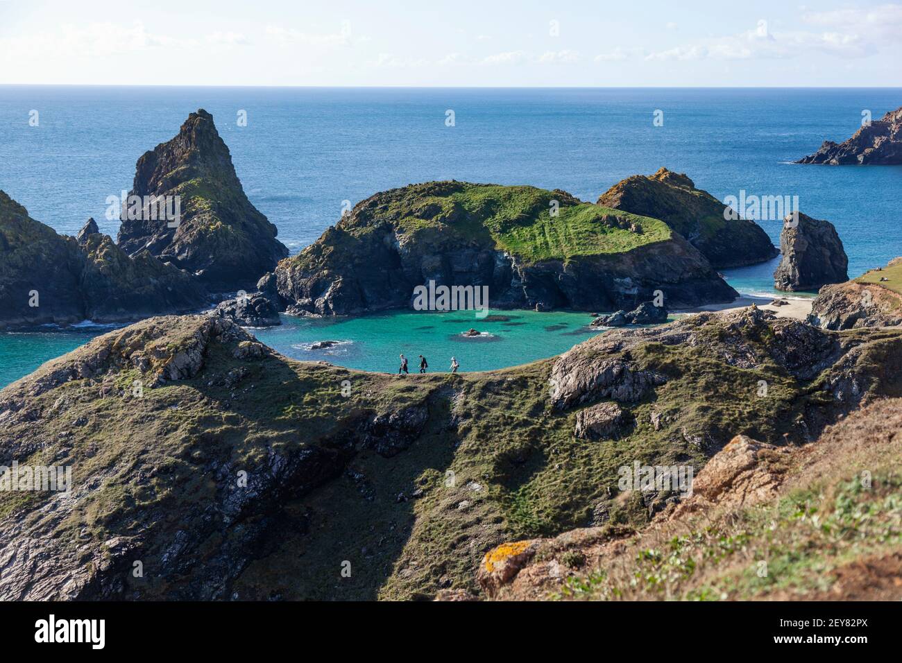 Vista elevata degli escursionisti su una cresta che si affaccia su Kynance Cove sulla penisola di Lizard in Cornovaglia, Regno Unito, in una giornata di sole Foto Stock
