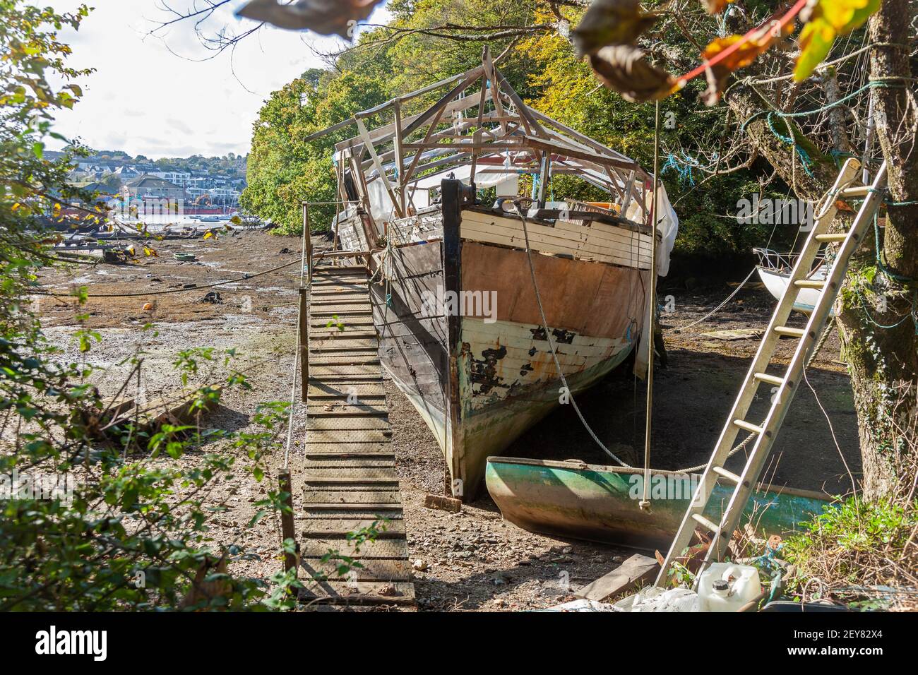 Una barca in fase di ristrutturazione a bassa marea in un torrente riparato vicino a Falmouth e Penryn, Cornovaglia, Regno Unito Foto Stock