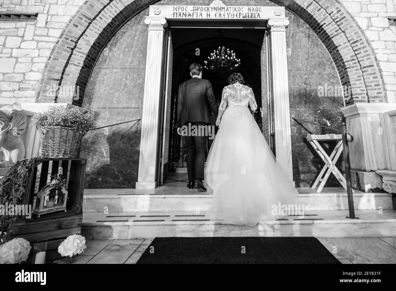 sposa e sposo entrano nella porta della chiesa Foto Stock
