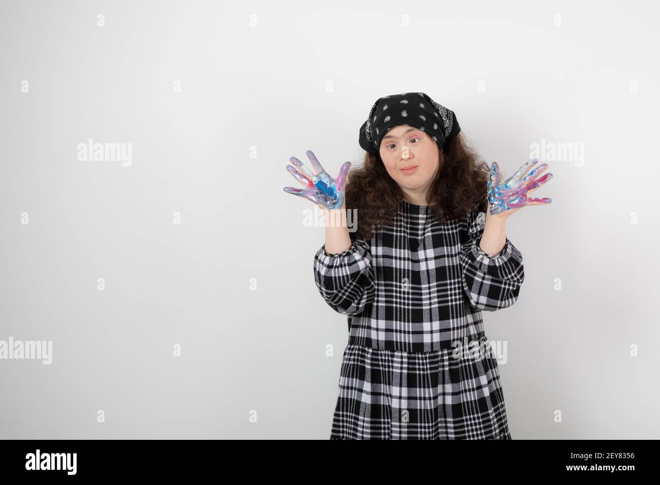 Giovane ragazza con sindrome di Down che mostra i colori su sfondo bianco Foto Stock