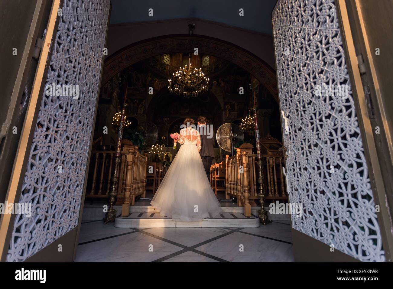 vista posteriore di sposa e sposo che cammina fino all'altare Foto Stock