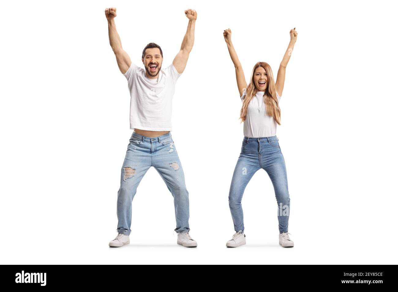 Ritratto a lunghezza intera di un giovane uomo e una donna dentro jeans e magliette bianche gesturing felicità con braccia sollevate isolate su sfondo bianco Foto Stock
