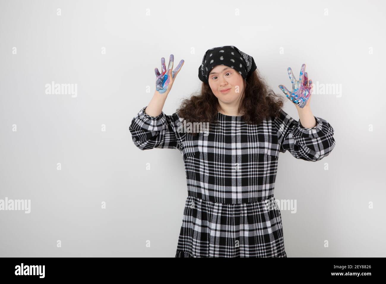 Giovane ragazza con sindrome di Down che mostra i colori su sfondo bianco Foto Stock