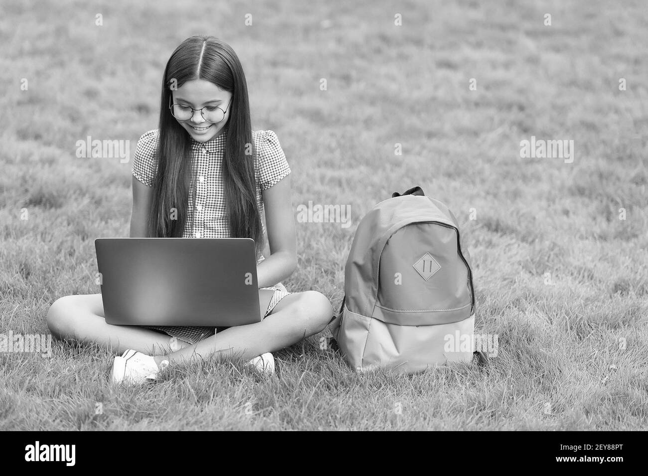 ragazza intelligente sorridente teen guardando lo schermo del notebook con espressione di entusiasmo e prendere appunti, la comunicazione nel concetto di business. Foto Stock