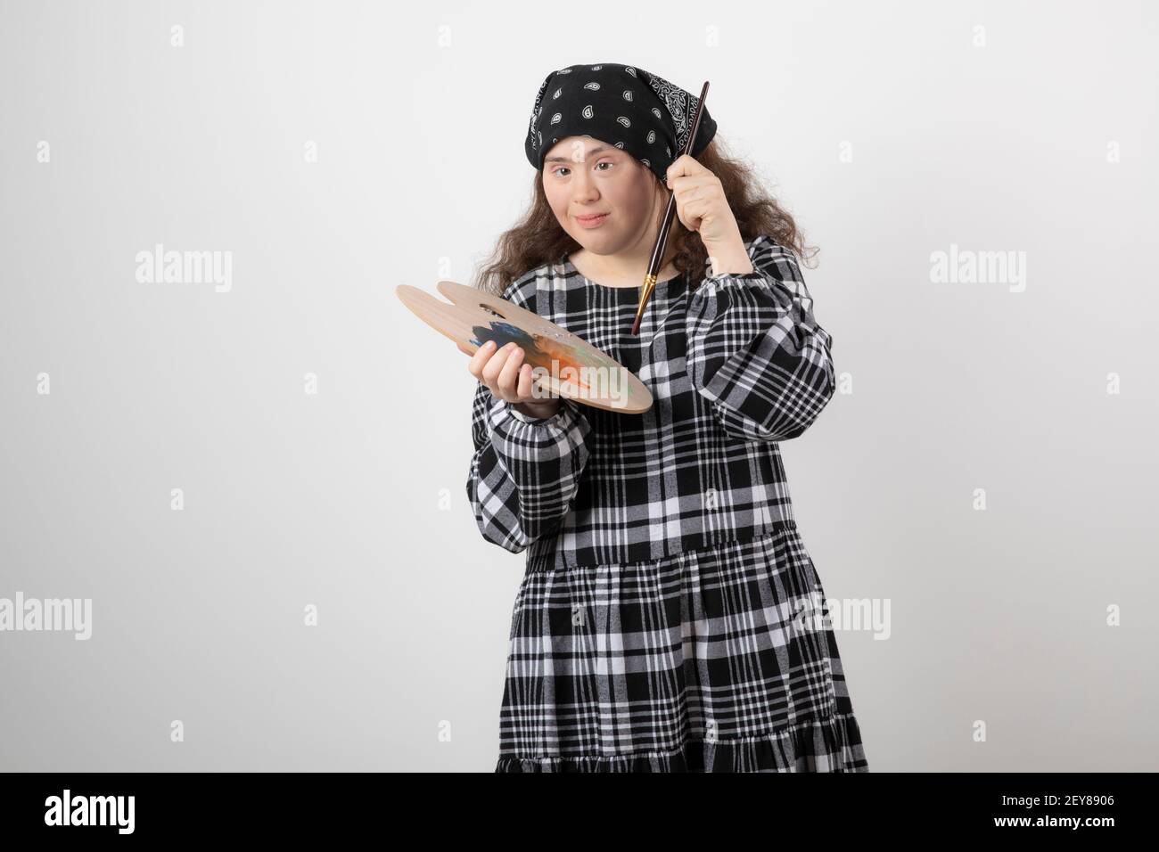 Adorabile giovane ragazza con sindrome di Down che tiene la tavolozza pittore Foto Stock