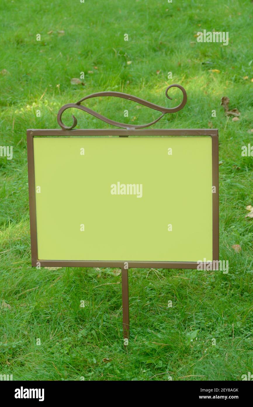 Cartello vuoto sul prato verde. Spazio vuoto per il testo, il mockup, lo spazio di copia. Foto Stock