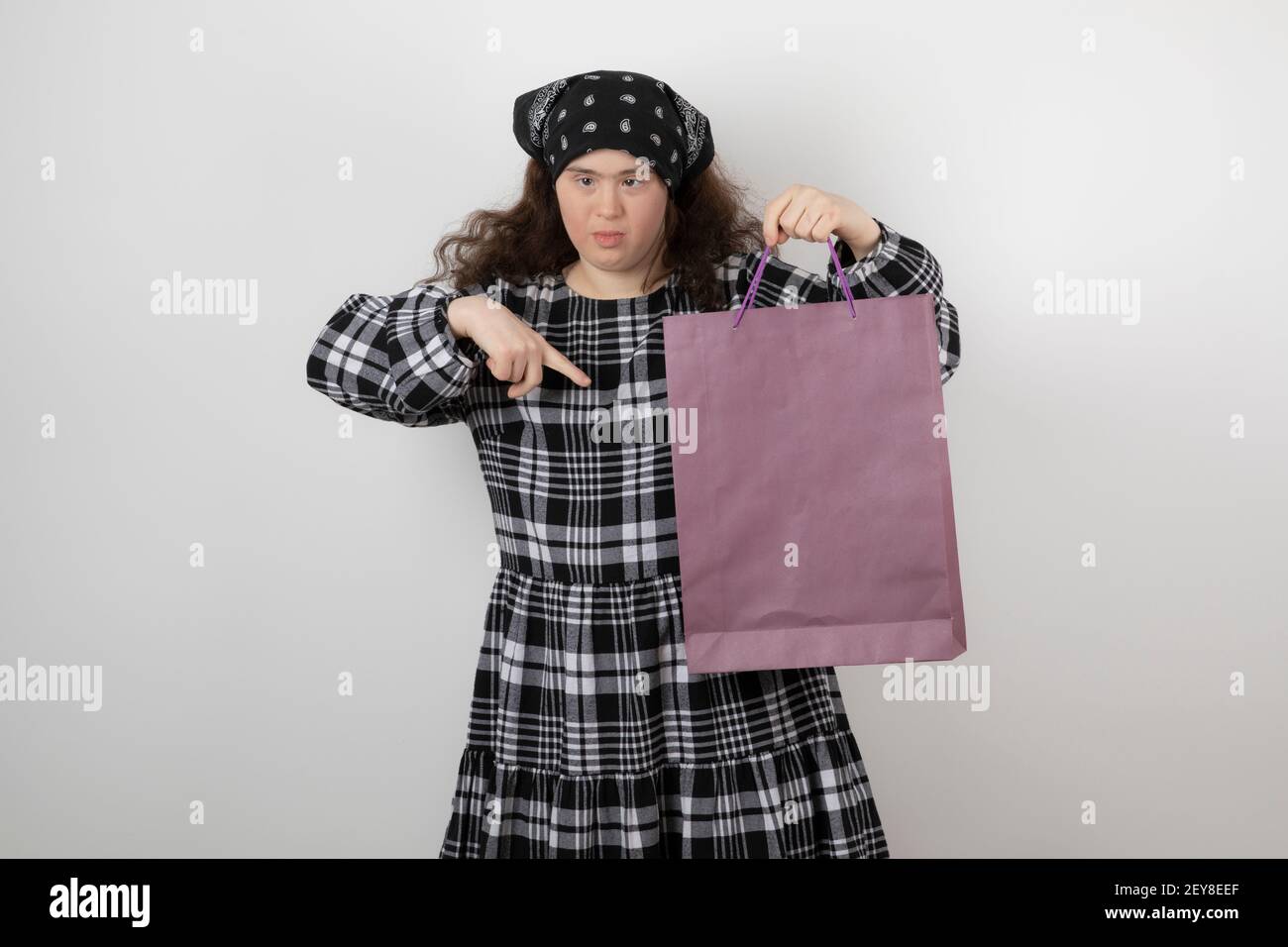 Adorabile giovane ragazza con sindrome di Down che tiene la borsa della spesa Foto Stock