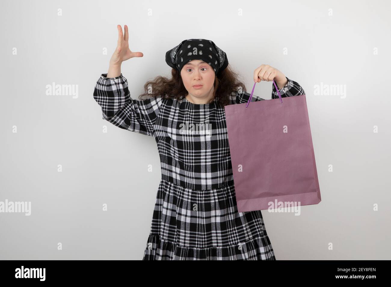 Adorabile giovane ragazza con sindrome di Down che tiene la borsa della spesa Foto Stock