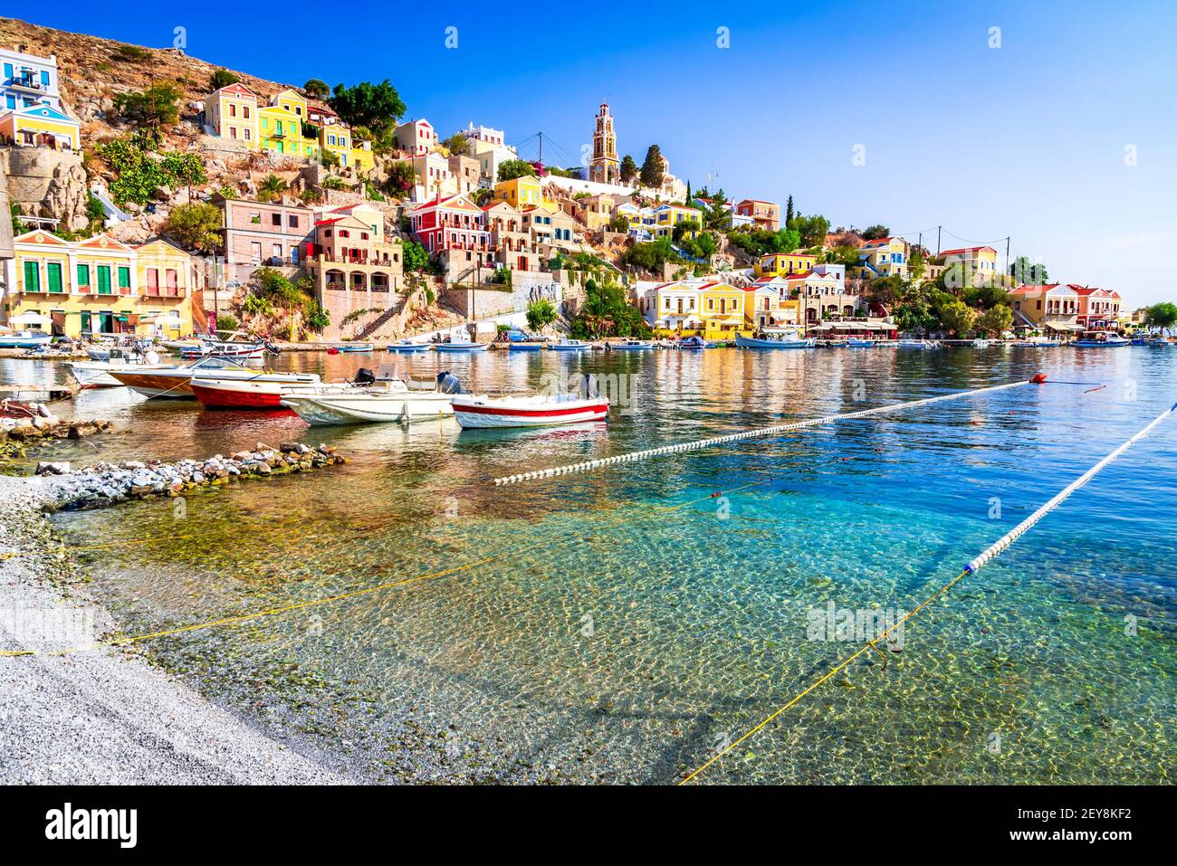 Isola di SYMI, Grecia. Isole Greche vacanze viaggi destinazioni da Rodi, Mar Egeo. Colorate case turche neoclassiche nella baia di Symi. Foto Stock