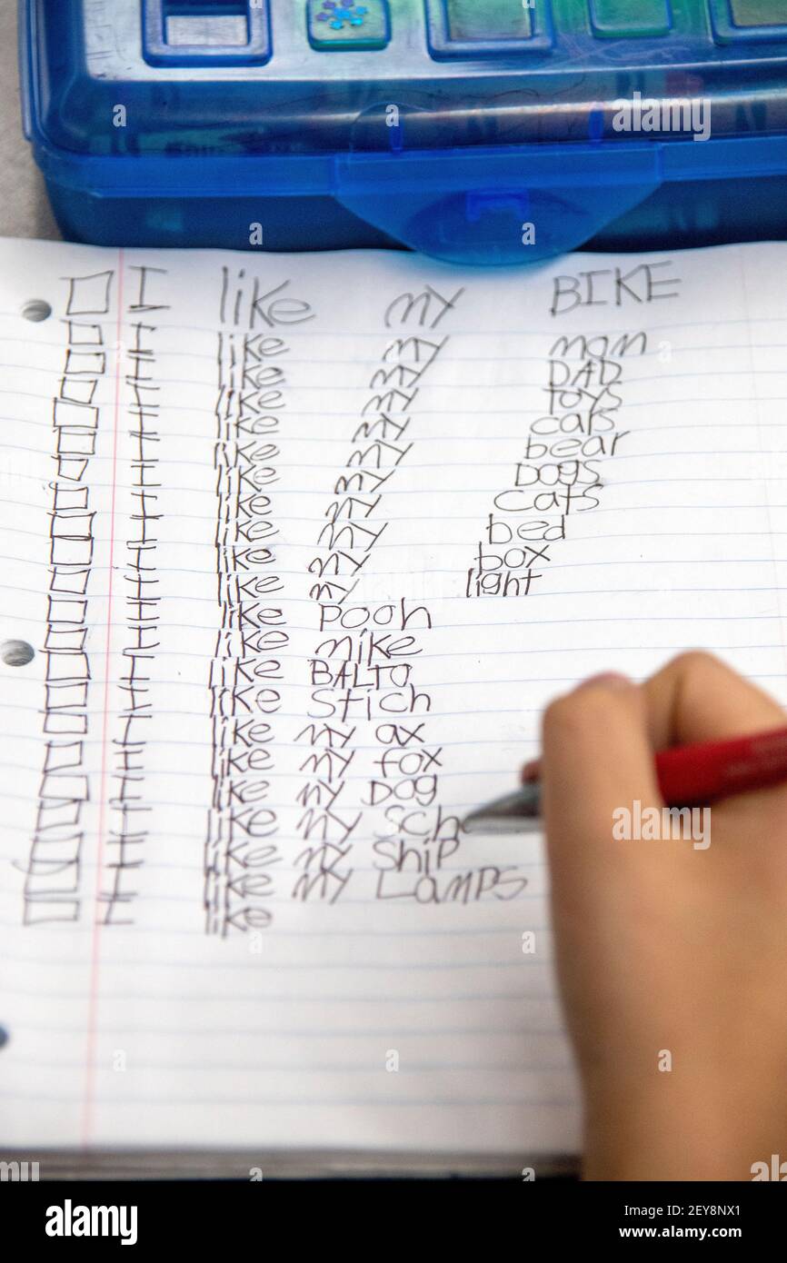 Uno studente californiano di terzo grado scrive frasi con soggetti diversi durante una lezione di arti linguistiche. Foto Stock