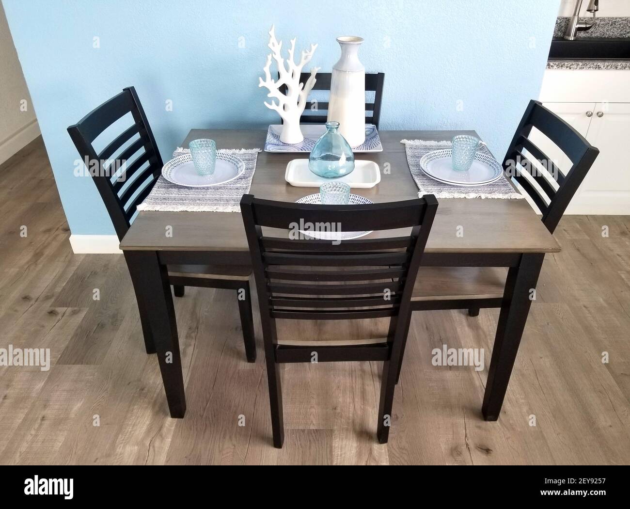 Un piccolo tavolo da cucina con quattro sedie e decorazioni sulla