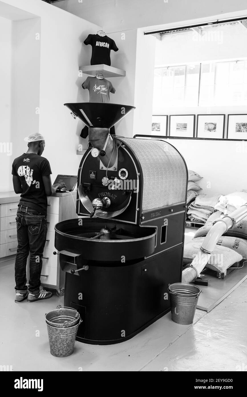 JOHANNESBURG, SUDAFRICA - 05 gennaio 2021: Johannesburg, Sudafrica - 14 gennaio 2013: African Man che aziona una macchina usata per tostare i chicchi di caffè Foto Stock