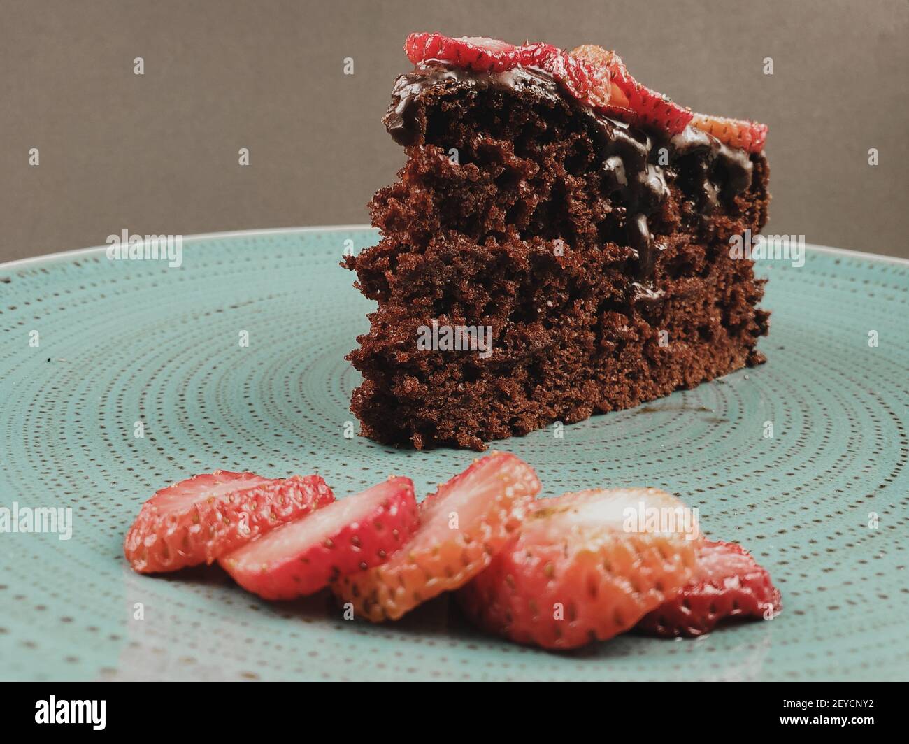 torta al cioccolato con fragole in piatto turchese, primo piano Foto Stock