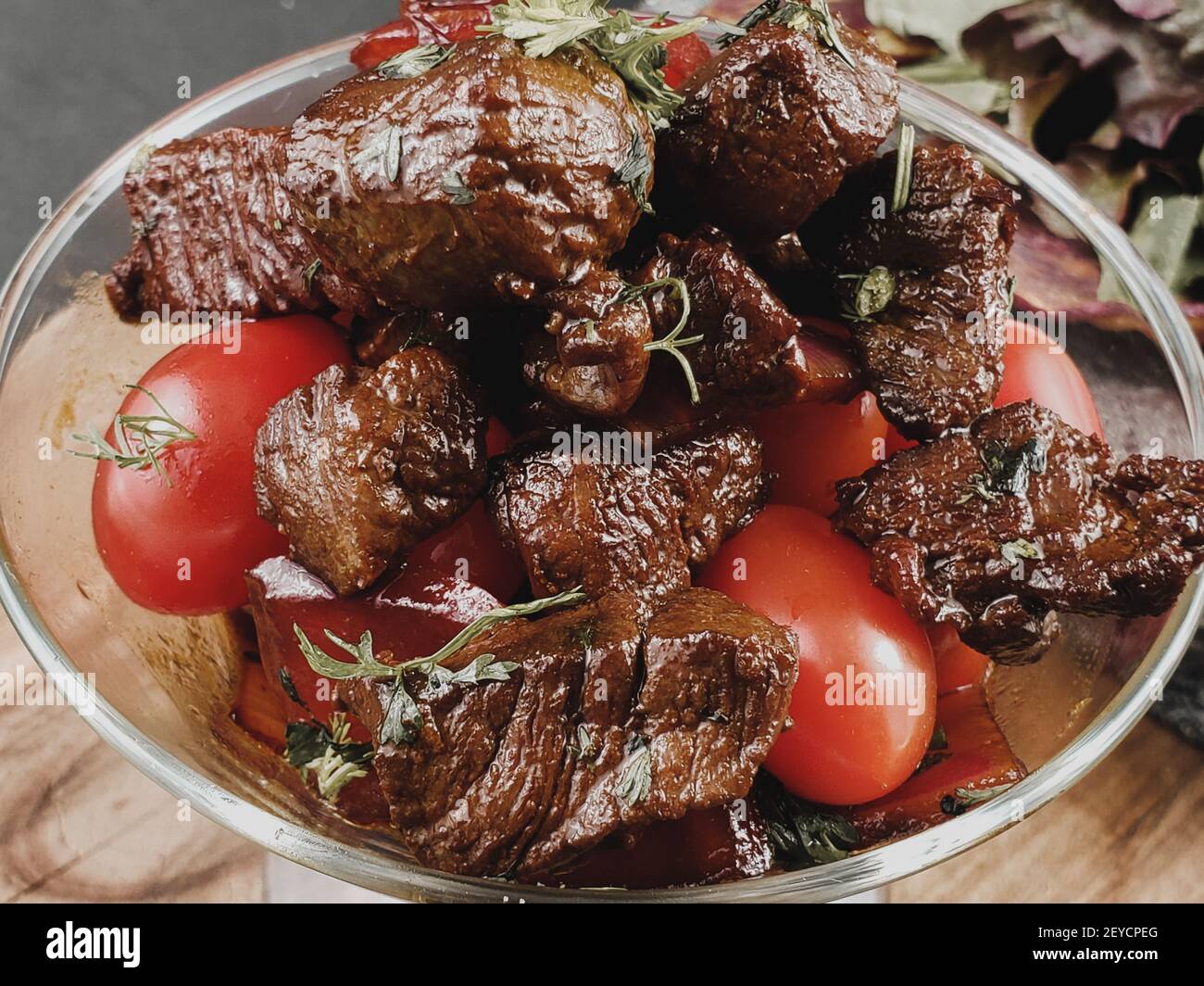 Fette di manzo alla griglia barbecue bistecca di controfiletto con insalata e pomodori e rucola sul tagliere close-up Foto Stock