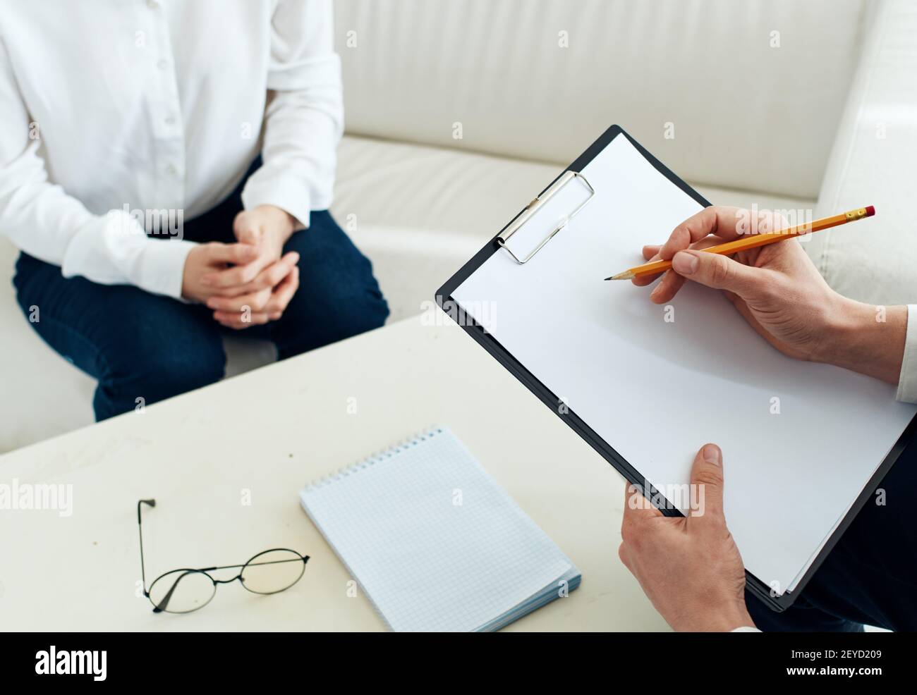 Foglio bianco di carta un uomo scrive le informazioni e un donna a un tavolo al chiuso Foto Stock