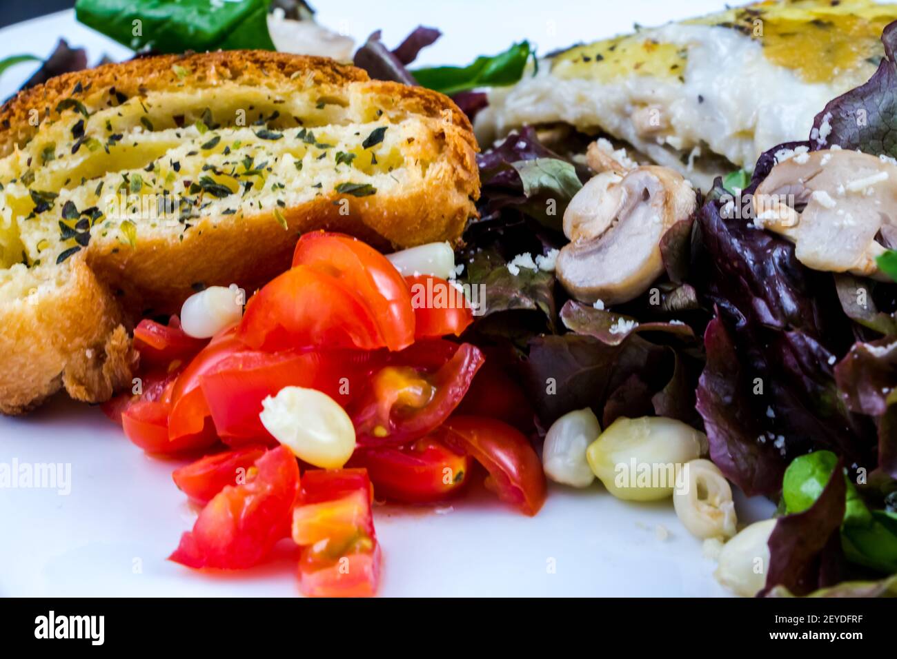 Porzione di lasagna farcita con insalata verde Foto Stock