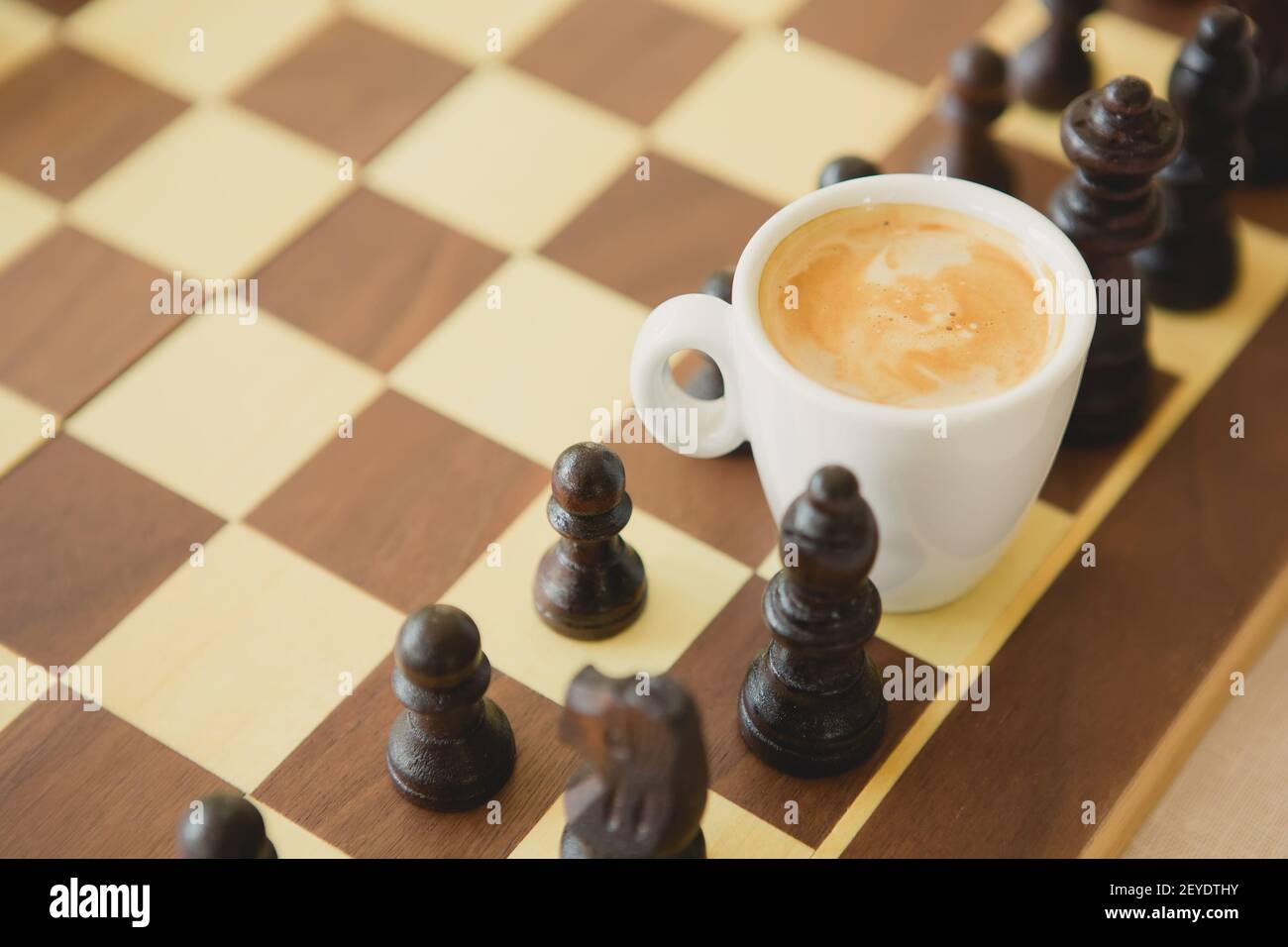 Tempo libero Tempo di relax o di strategia aziendale concetto. Parte della tavola scacchi con tazza di caffè Foto Stock