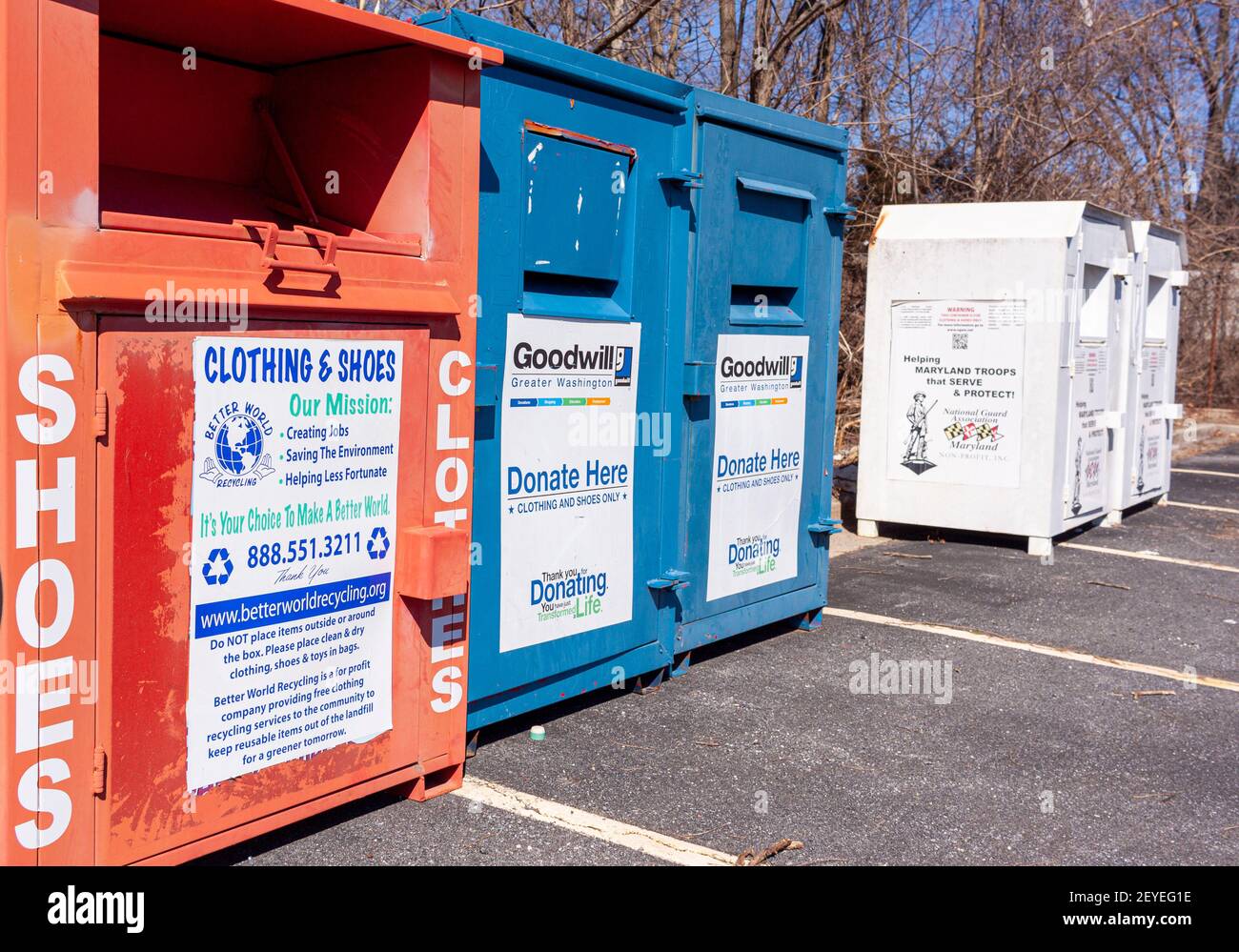 Rockville, Maryland, USA 03-02-2021: Bidoni di donazione di grandi abiti e scarpe in metallo allineati fianco a fianco su un parcheggio. Aiutano a ridurre sprechi e beni Foto Stock