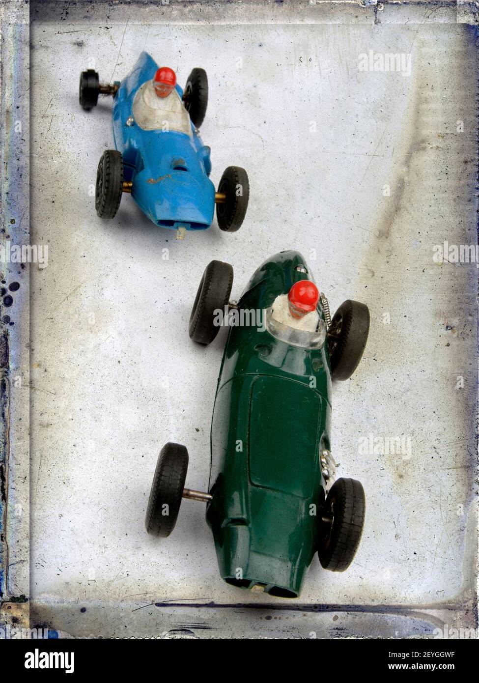 Auto da corsa giocattolo d'epoca in movimento su una superficie testurizzata con colori vivaci e design unici durante un pomeriggio divertente Foto Stock Auto da corsa giocattolo d'epoca in movimento su una superficie testurizzata con colori vivaci e design unici durante un pomeriggio divertente Foto Stock
