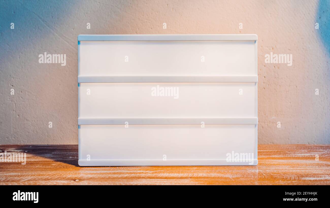 Scatola luminosa da cinema vuota mockup alla luce del sole su supporto in legno per il tuo testo Foto Stock