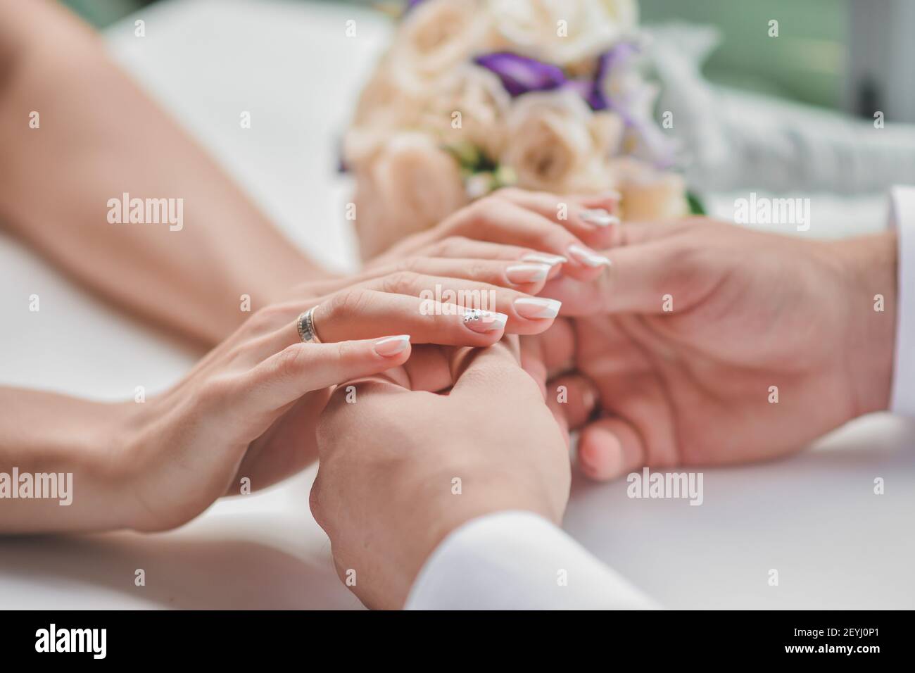 Un ragazzo tiene le mani della sua fidanzata. L'uomo diede alla donna un mazzo di fiori. Foto Stock