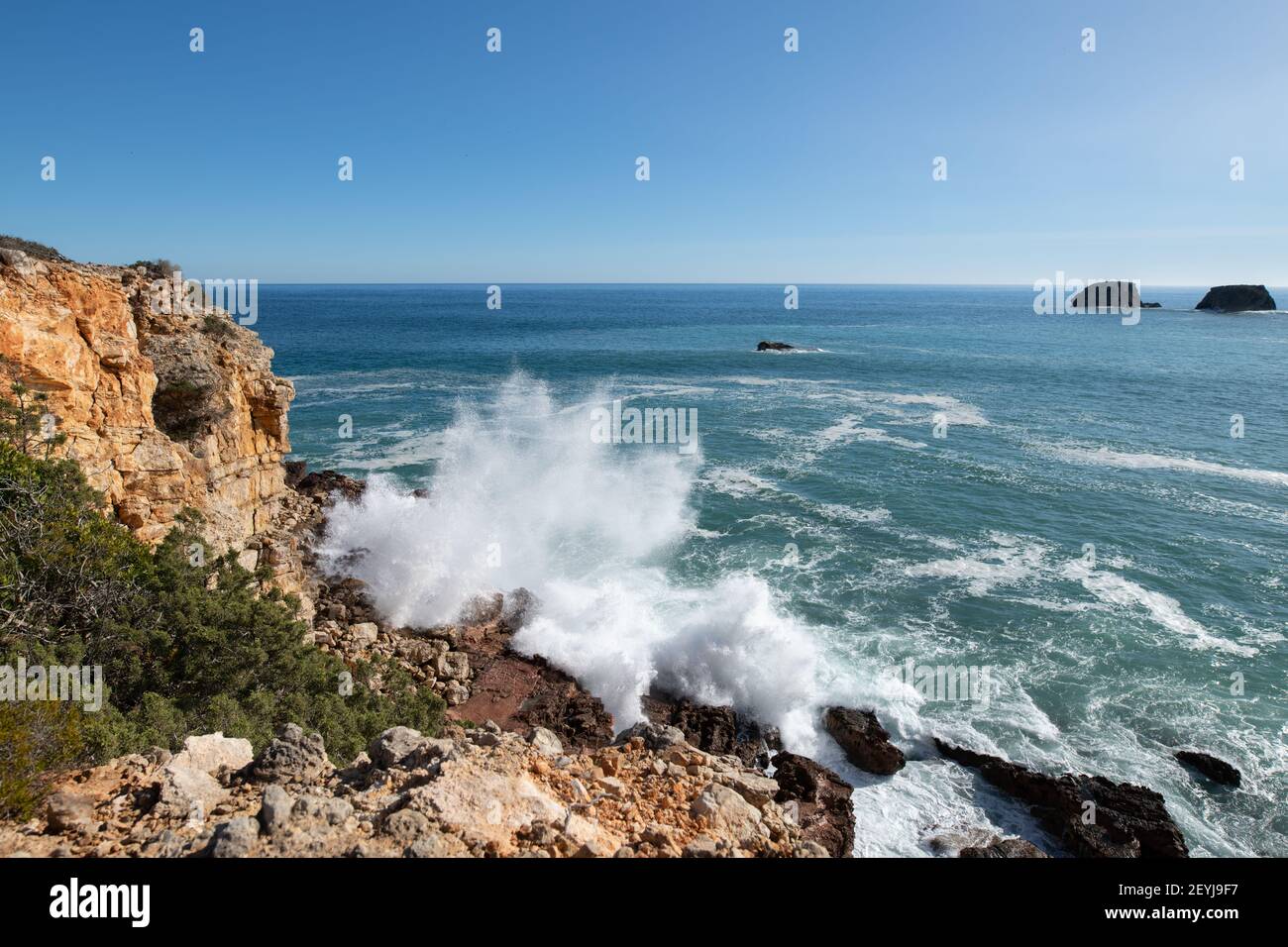 Onde che si infrangono sulle rocce sulla costa dell'Algarve Foto Stock