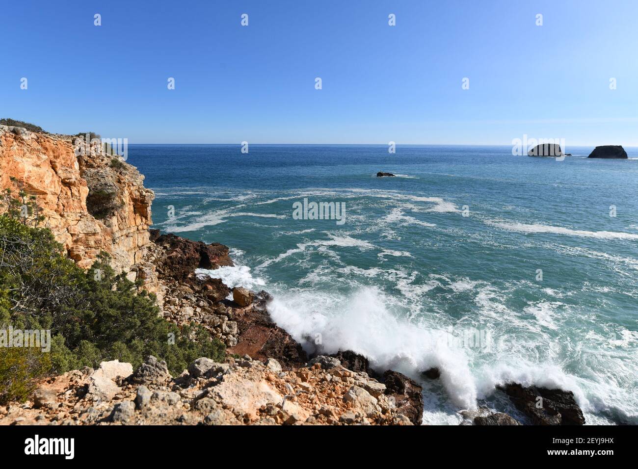 Onde che colpiscono la base delle scogliere sulla parte occidentale Algarve in Portogallo Foto Stock