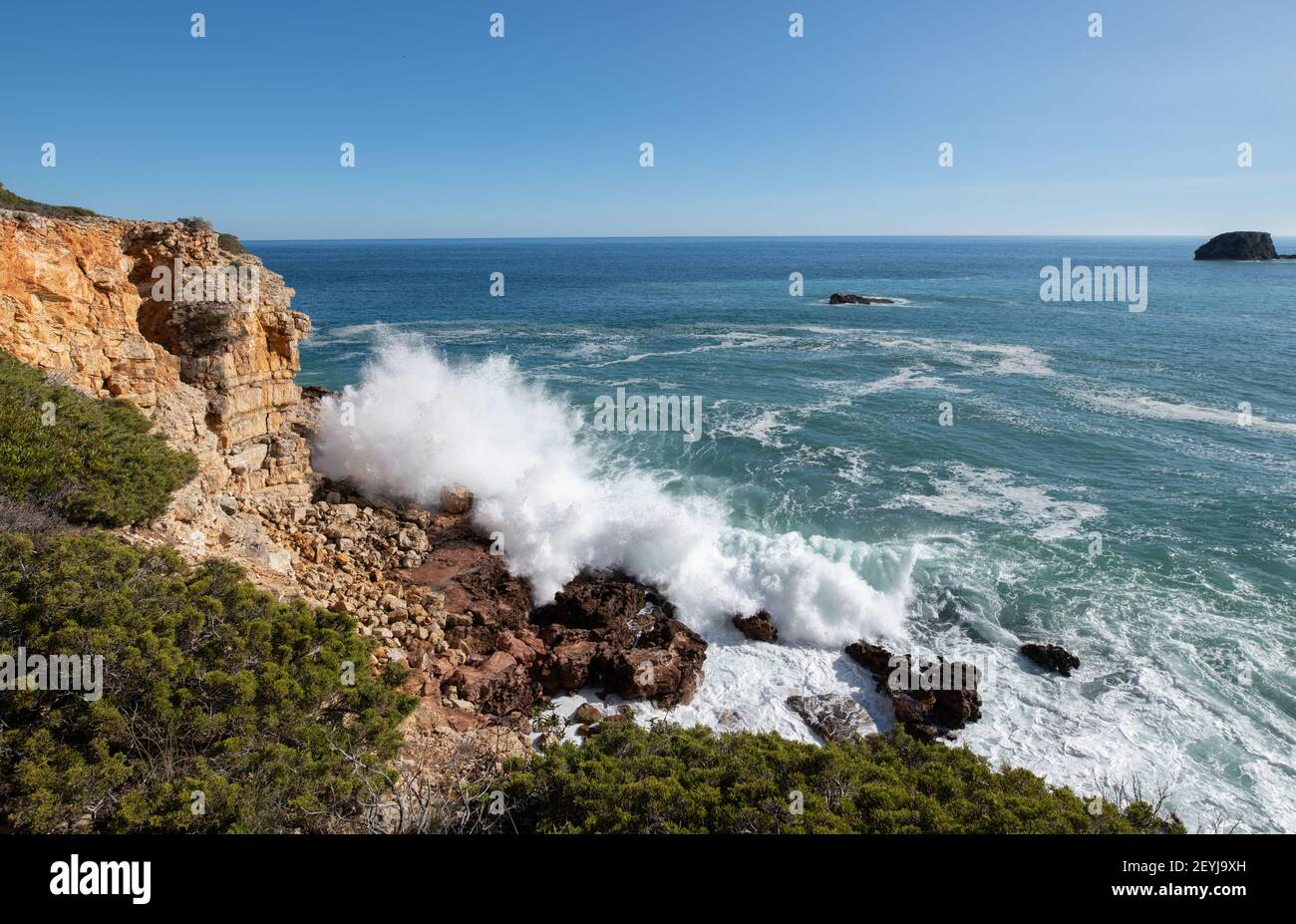 Onde che si infrangono sulle rocce sulla costa dell'Algarve Foto Stock