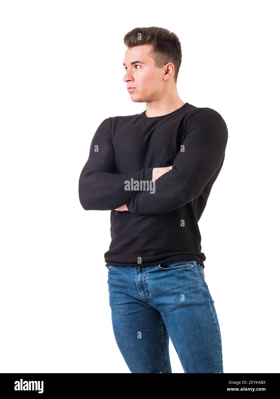 Bel giovane uomo in maglione nero in piedi, braccia incrociate sul petto Foto Stock