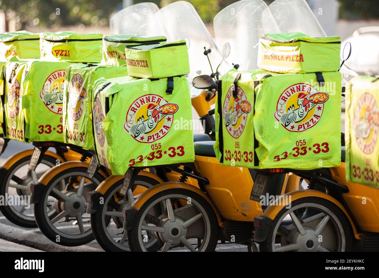 Firenze, Italia - 2021 febbraio 24: Scooter con sacchi per la consegna della pizza, parcheggiati di fila. Foto Stock