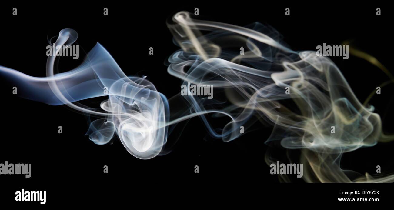 Forme astratte di fumo blu e giallo su sfondo nero isolato Foto Stock