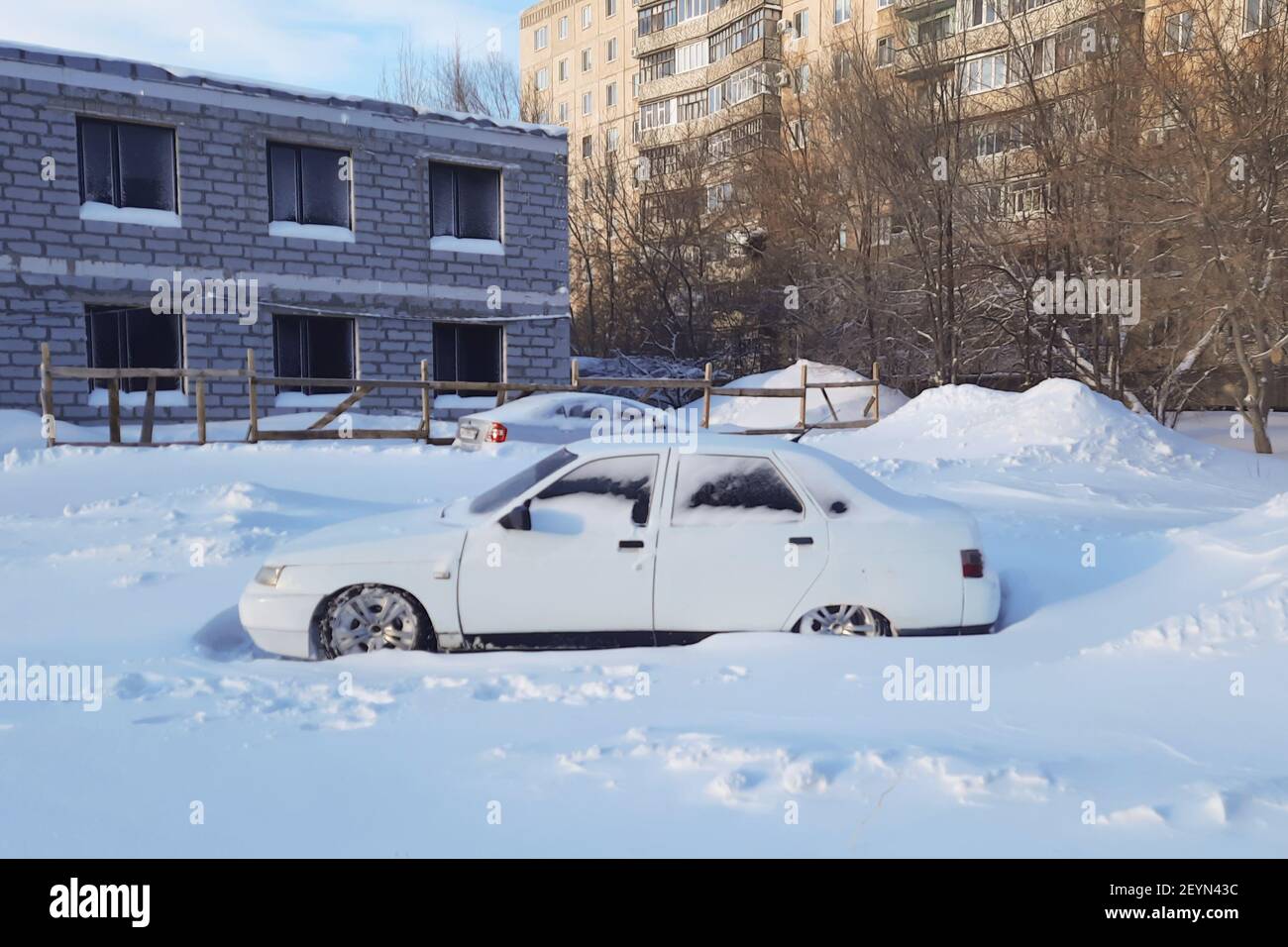 Auto bianca coperta di neve con bassa altezza da terra., Foto Stock