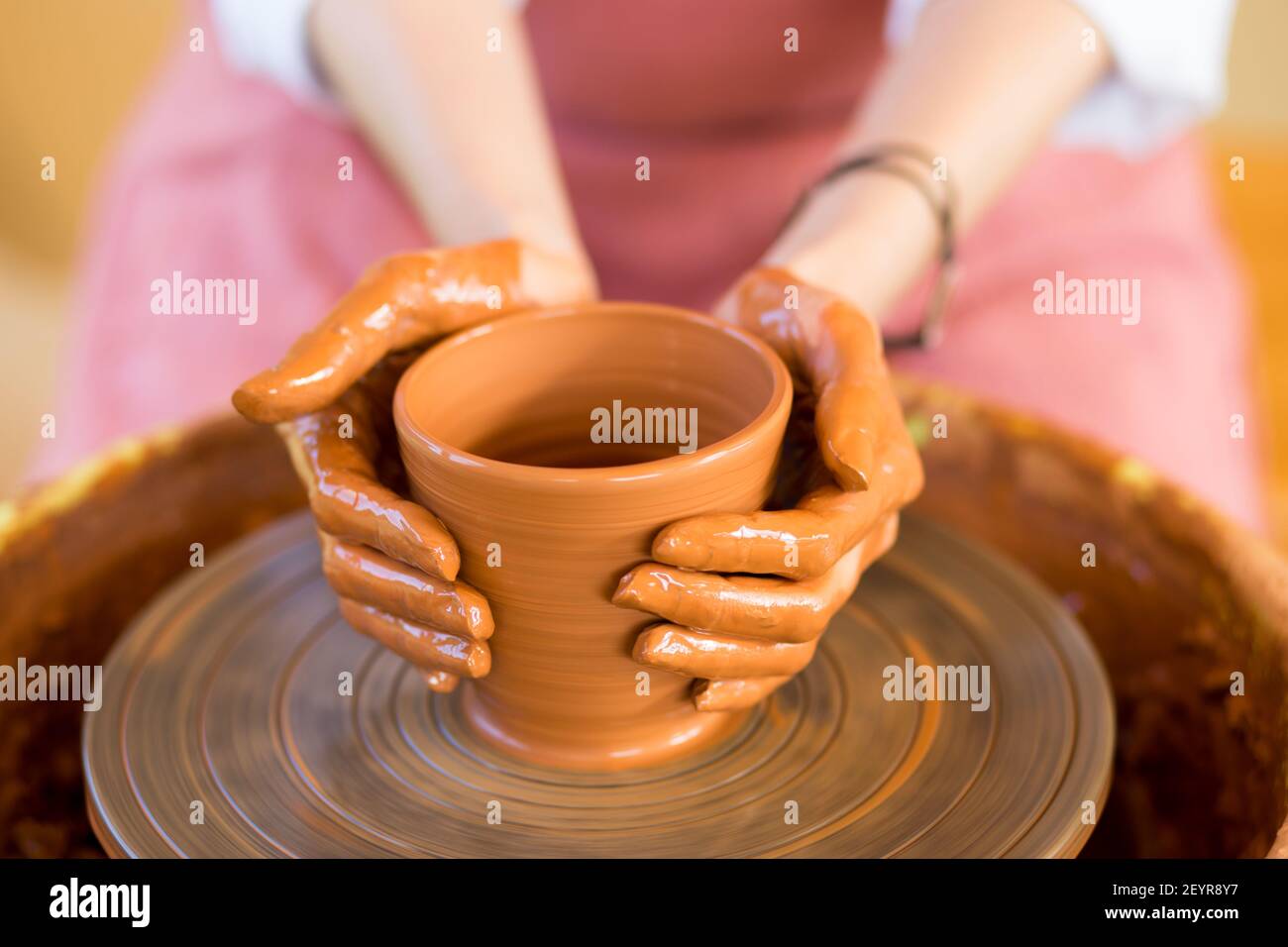 Le mani della donna scolpisce la tazza dal vaso di creta. Laboratorio di modellazione su ruota di vasaio. Foto Stock