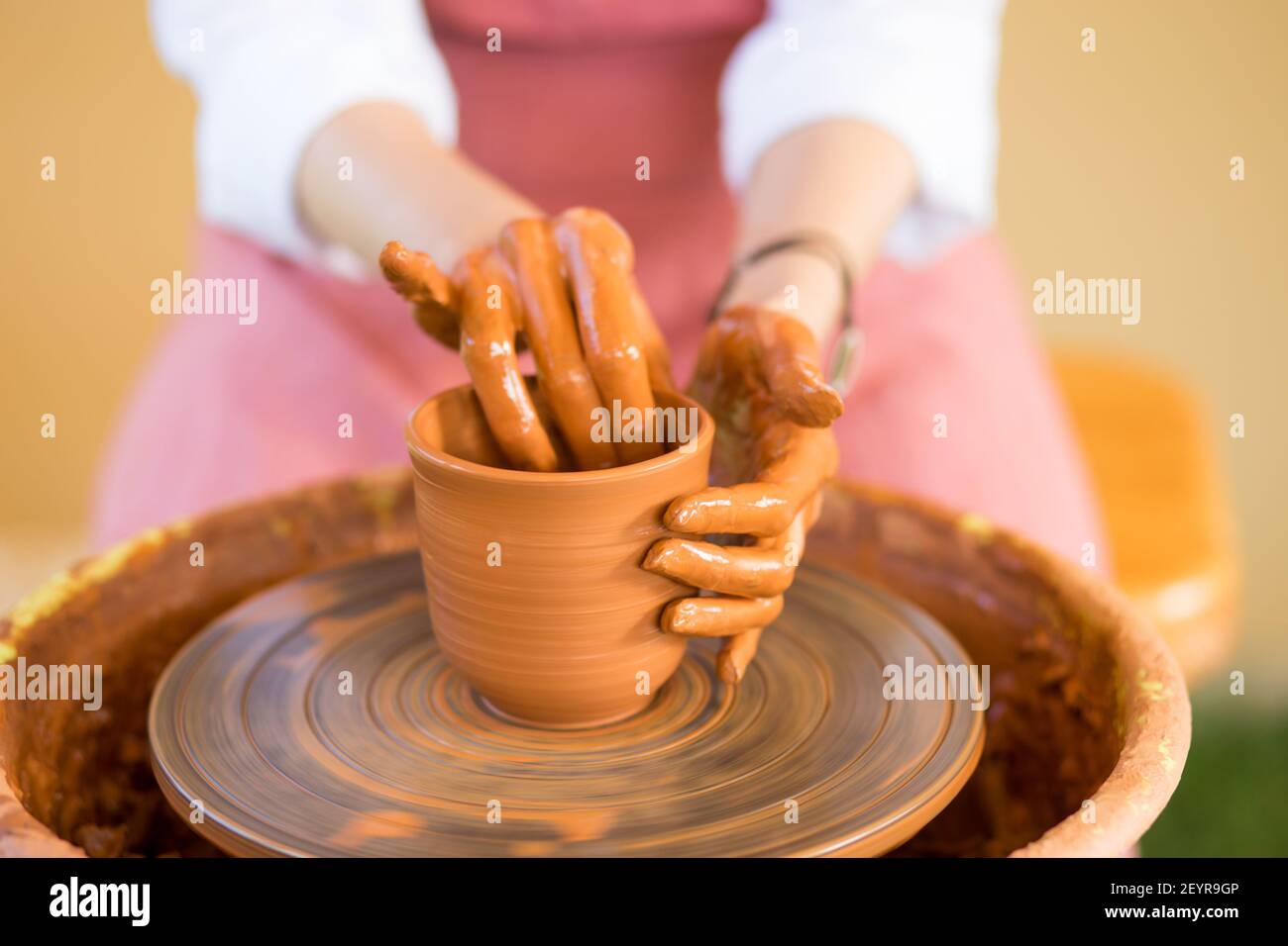 Le mani della donna scolpisce la tazza dal vaso di creta. Laboratorio di modellazione su ruota di vasaio. Foto Stock