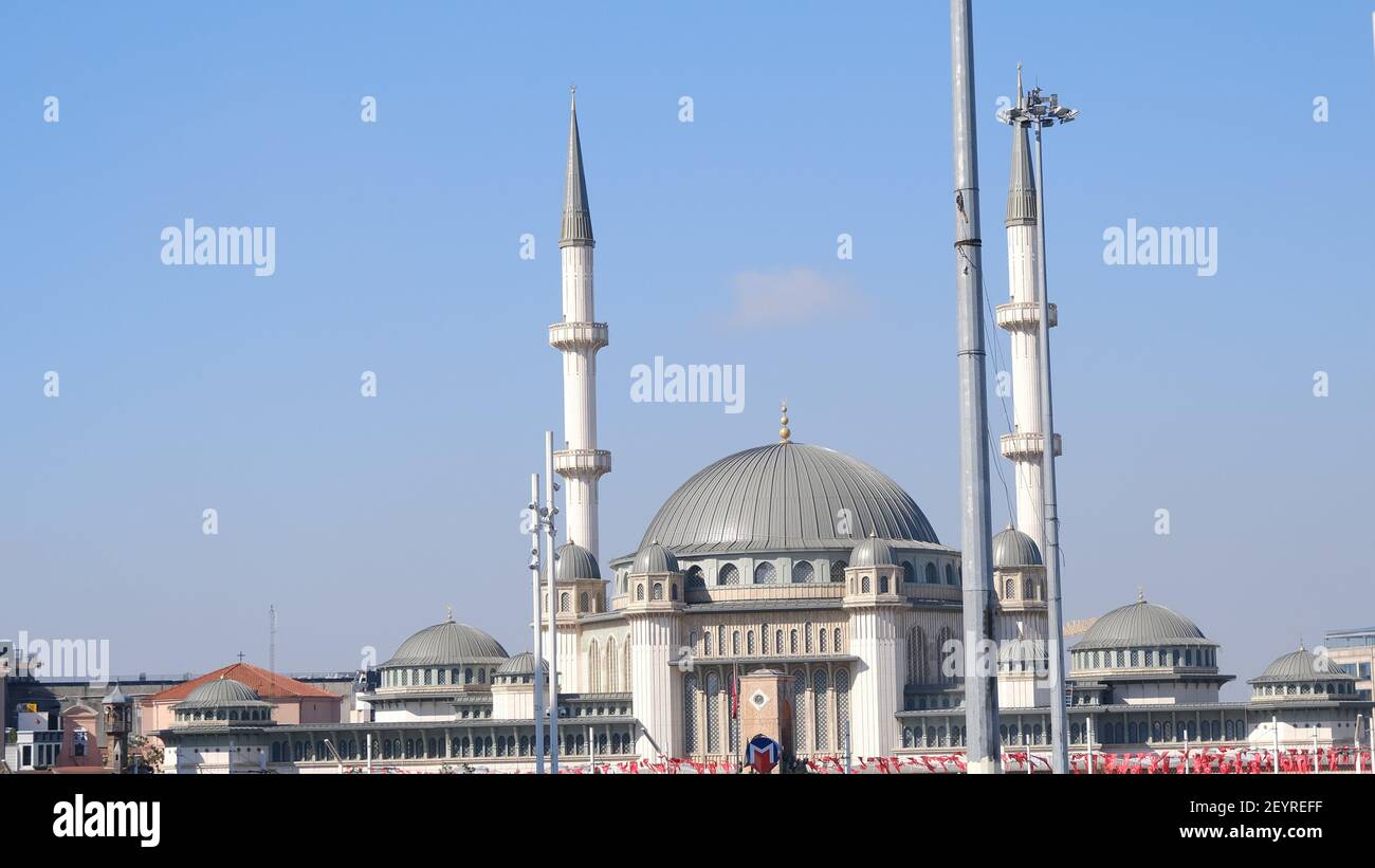 istanbul, una delle piazze più famose di piazza taksim durante il giorno di sole. Molte bandiere turche impiccano di fronte alla moschea di taksim Foto Stock