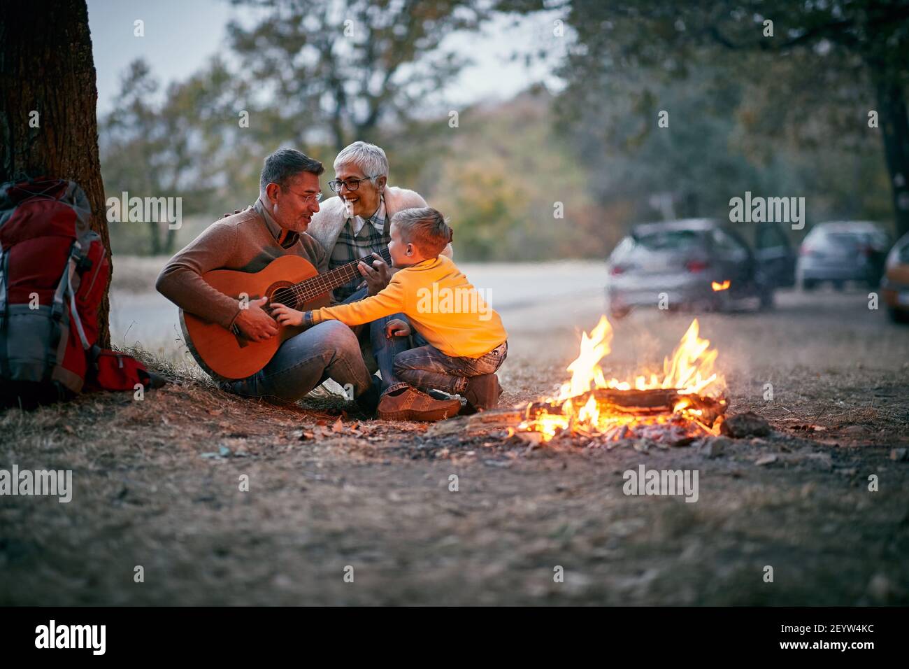 Nonni con nipote al picnic godendosi con la chitarra Foto Stock