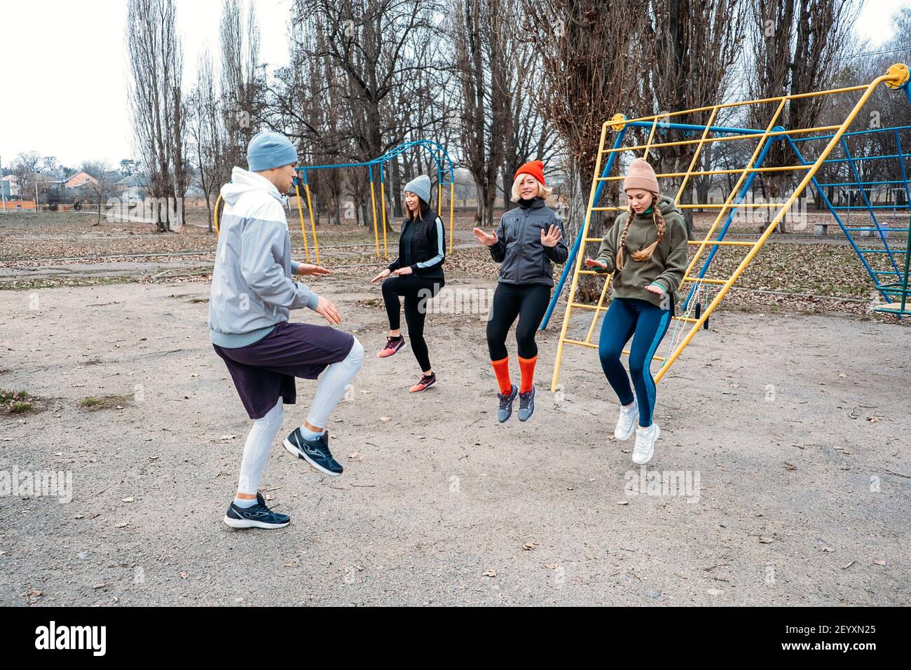 Corsi di fitness di gruppo all'aperto. Corsi di ginnastica organizzati nei parchi pubblici. Tre donne e tre uomini si allenano insieme nel parco pubblico. Salute Foto Stock