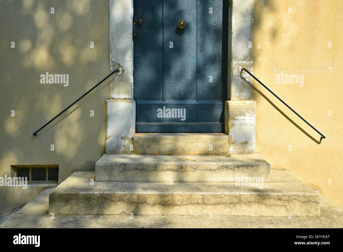 Facciata vecchia casa Provençal con una porta di legno blu e scalini in pietra con ringhiere in ferro a Saint-Rémy-de-Provence Francia. Foto Stock