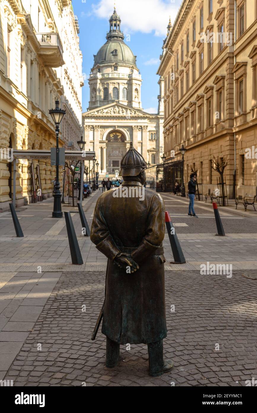 La statua del poliziotto grasso a Budapest che guarda a Santo Stefano Basilica Foto Stock