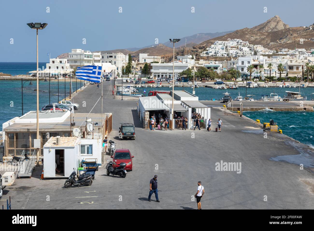 Naxos, Grecia - 26 settembre 2020: Vista sul porto dell'isola di Naxos. Persone in attesa del traghetto. Tradizionale edificio bianco sulle colline. Fla greca Foto Stock