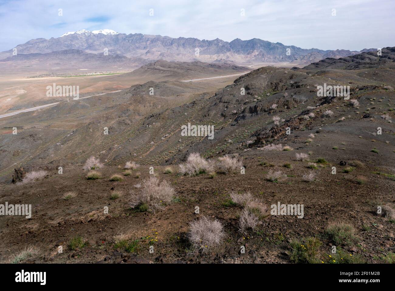 La catena montuosa del Karkas sorge sopra il deserto nella provincia di Isfahan in Iran. Villaggio di Tarq sotto. Foto Stock