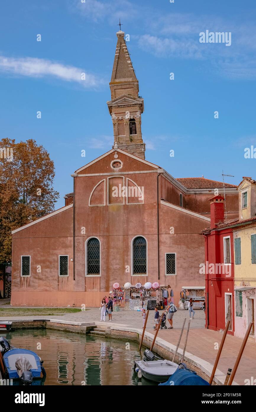 La Torre Pendente della Chiesa di San Martino Vescovo, con luminose e colorate Case Veneziane lungo il canale dell'Isola di Burano - Venezia, Veneto, Italia - Sceni Foto Stock