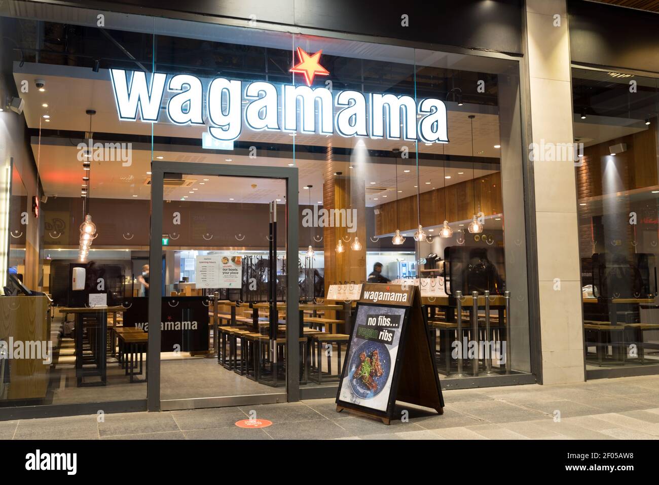 Il personale di Wagamama prepara piatti caldi all'interno del ristorante per il take-away A Londra Foto Stock