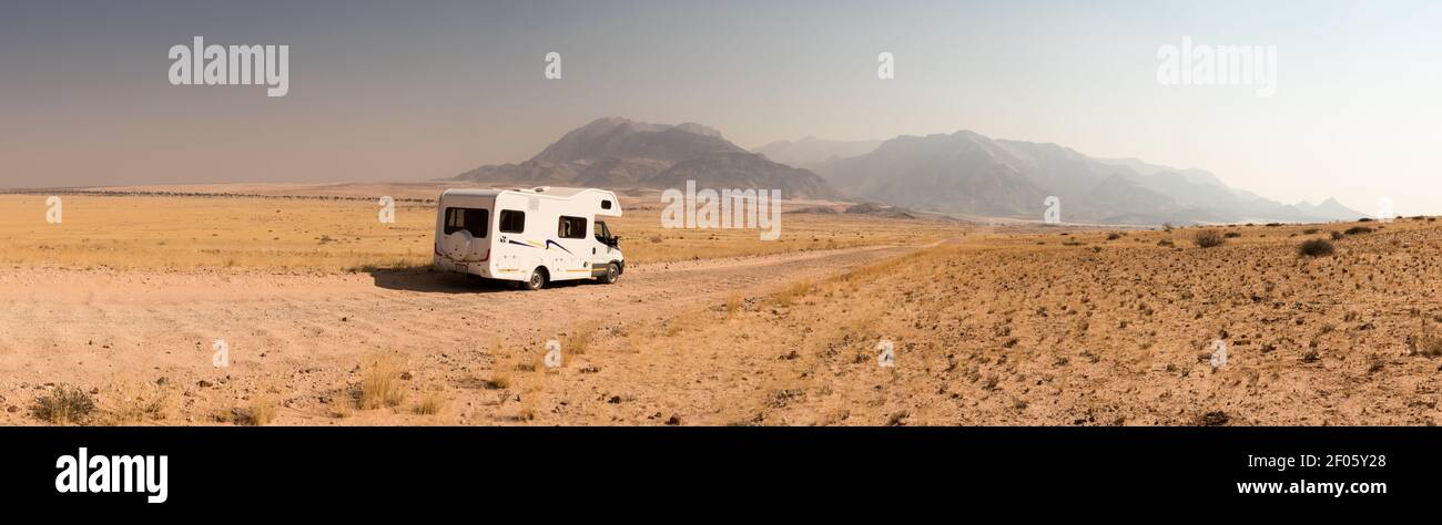 Viaggio su strada in una casa di camper attraverso la bellissima Damaraland, Namibia. Infinite strade ghiaiose che conducono ai monti Brandberg Foto Stock